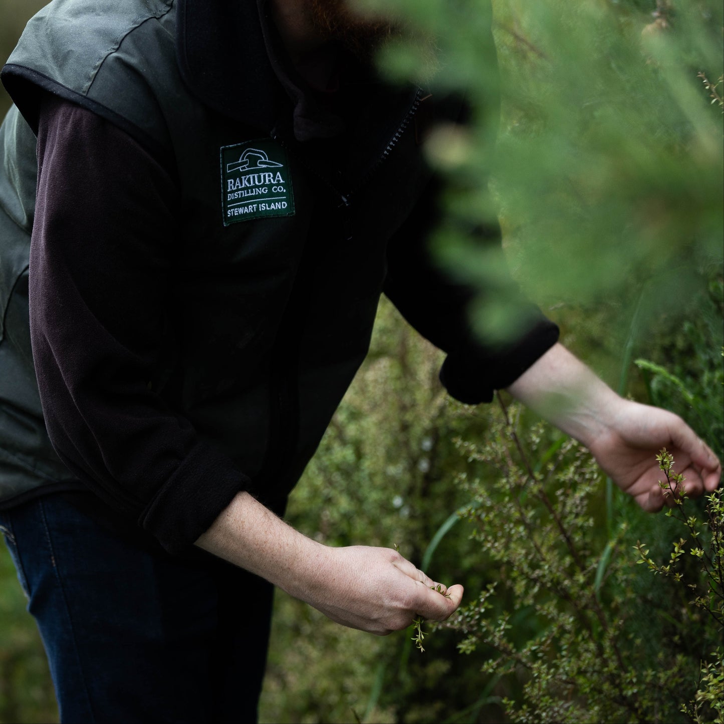 Person wearing a jacket with a brand logo in a natural setting
