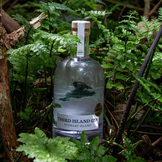 Bottle of Third Island Gin surrounded by green foliage