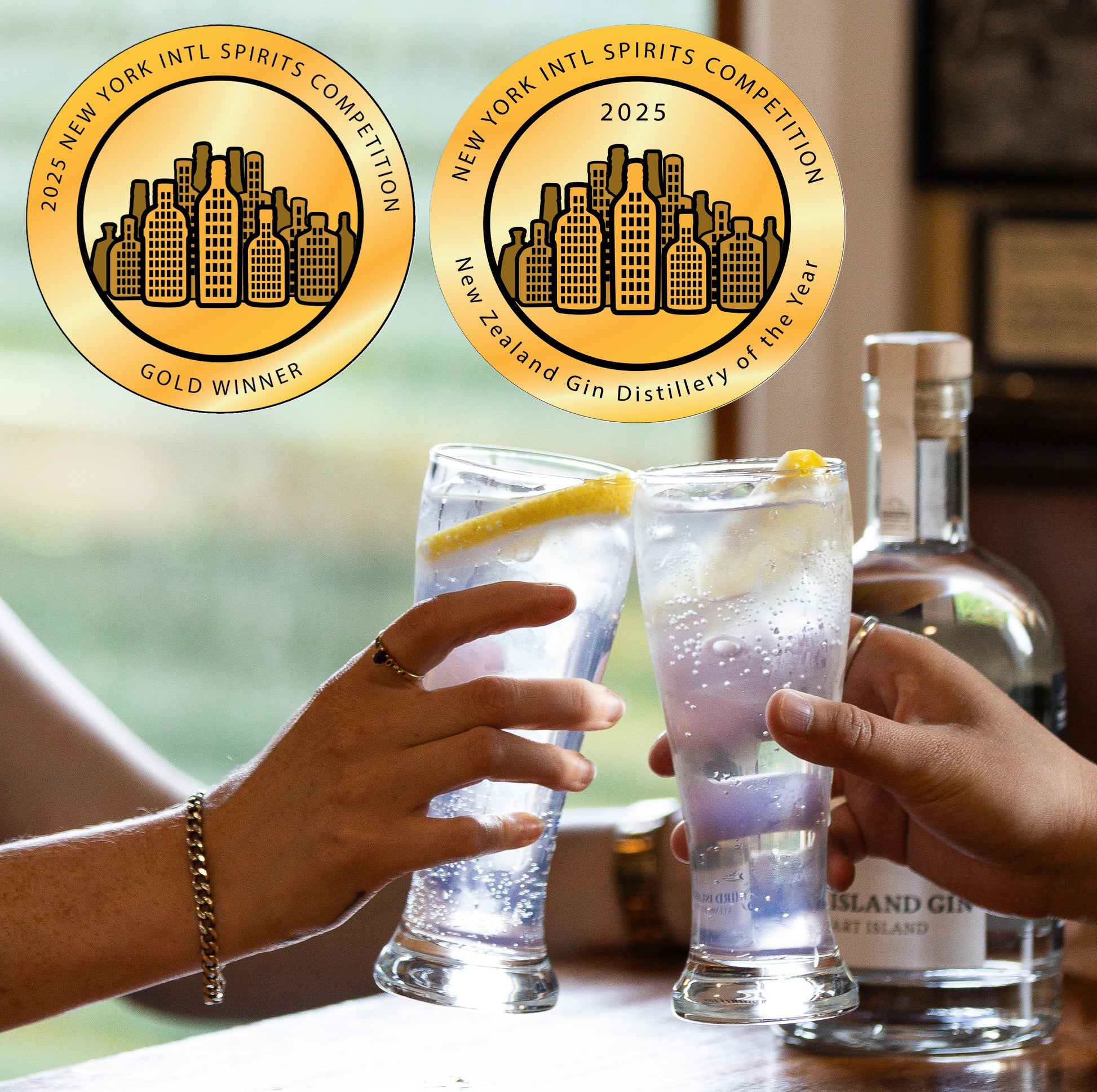 Two hands clinking glasses with a Third Island Gin bottle in the background, featuring gold awards for the New York International Spirits Competition.