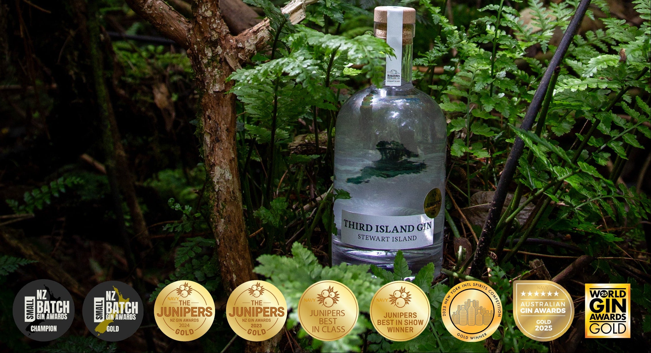 Bottle of Third Island Gin surrounded by greenery with multiple gold labels displayed.